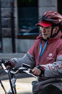 Ca 60 jähriger Mitarbeiter eines Lieferdienstes auf dem Fahrrad https://pixabay.com/photos/delivery-man-food-service-order-4756327/